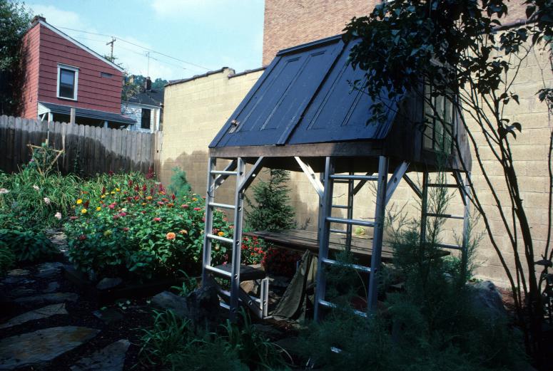 slide IRC.2012.00071 (old number: ACC.V-M008) showing Vito Acconci's garden installation, Making Shelter: House of Used Parts, at the Mattress Factory, 1986.